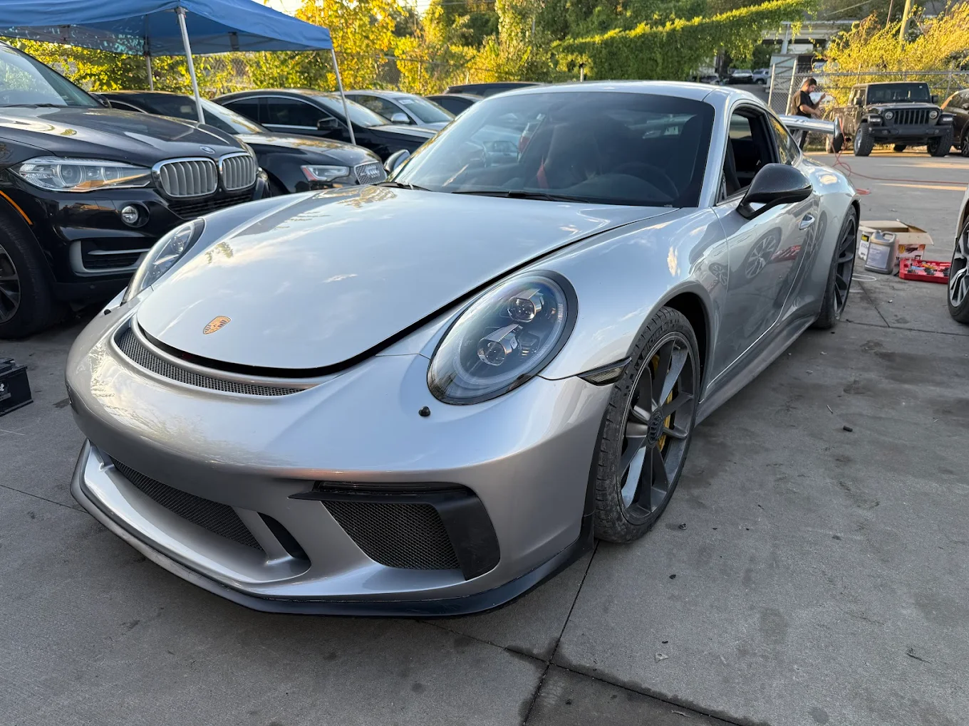 Silver Porsche 911 GT3 in for service at Mentor Auto Service, with a BMW and Audi in the background.